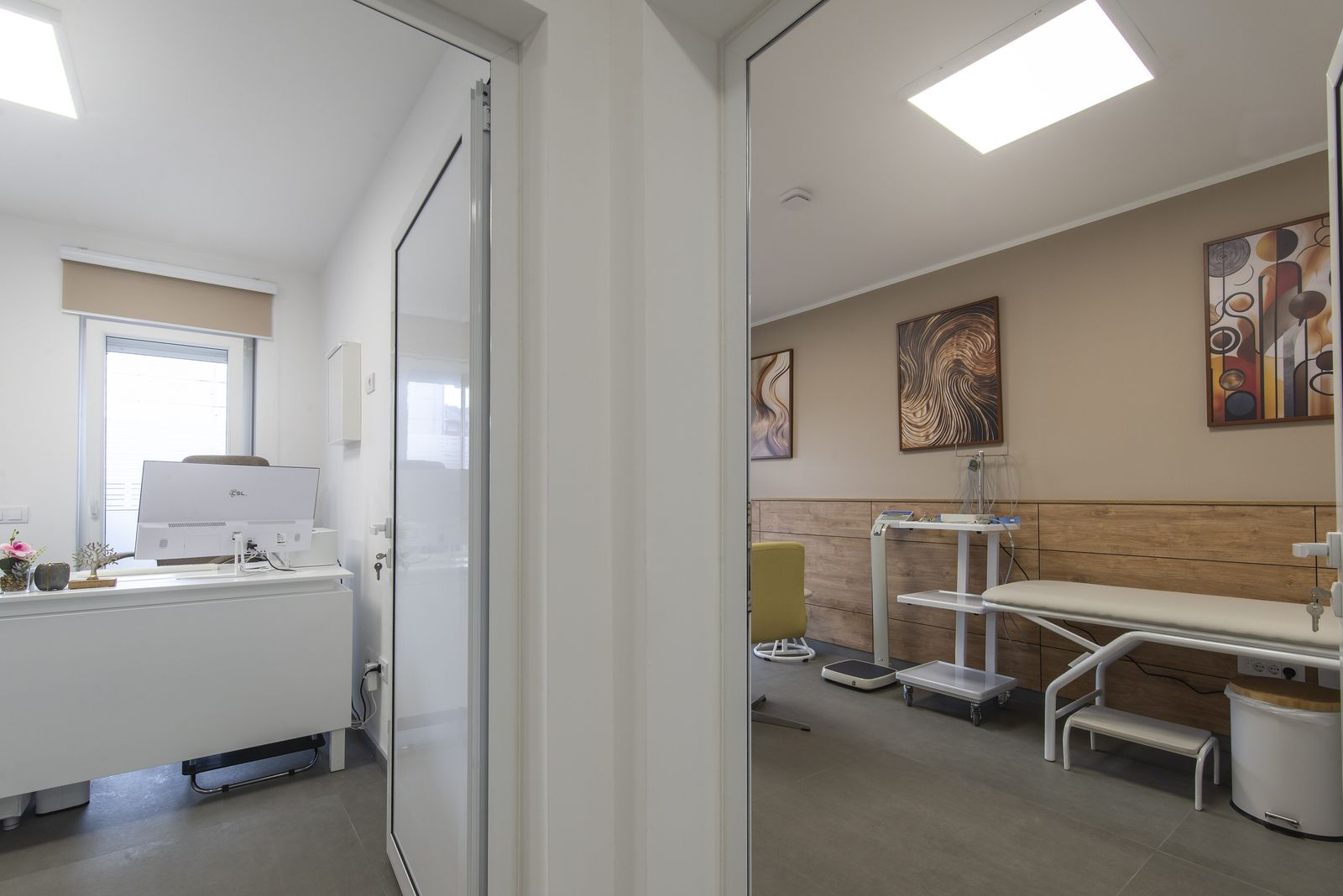 A clinic consulting room with a desk and an examination couch